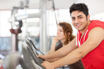 Man is doing workout on a bicycle at the gym