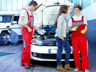 Customer and mechanic in a garage looking at a quotation