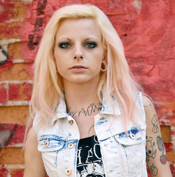 Frau mit Tattoos vor roter Wand