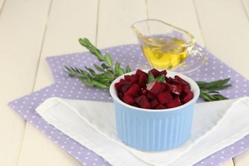 Sliced beetroot on bowl on wooden table close-up