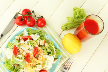 Caesar salad on blue plate, on color wooden background