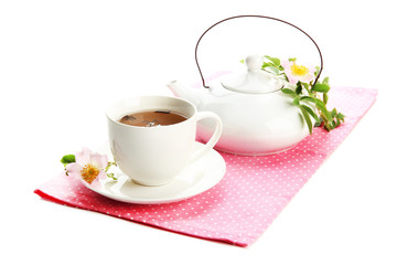 Cup and teapot of herbal tea with hip rose flowers, isolated