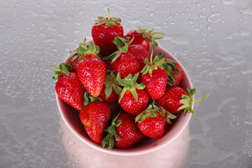 Strawberries in bowl on metal background