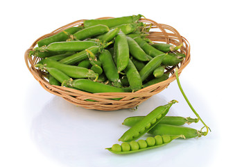 Sweet green peas in wicker basket isolated on white