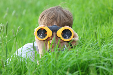 Junge mit Fernglas auf der Wiese