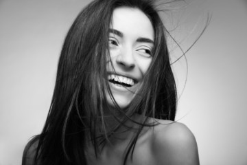 Attractive smiling woman with long hair on grey