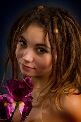 Naklejka premium young woman with dreadlocks against a dark background