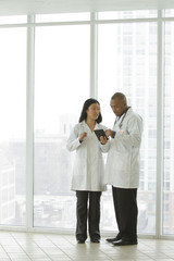 Wide shot of two doctors looking at a tablet
