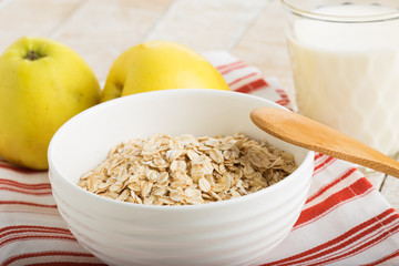 Oat flakes in bowl with apples and milk