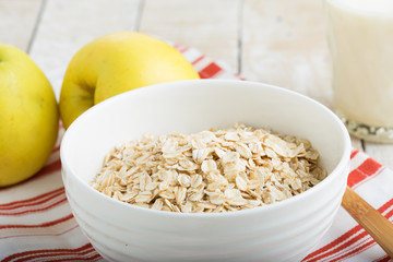 Oat flakes in bowl with apples and milk