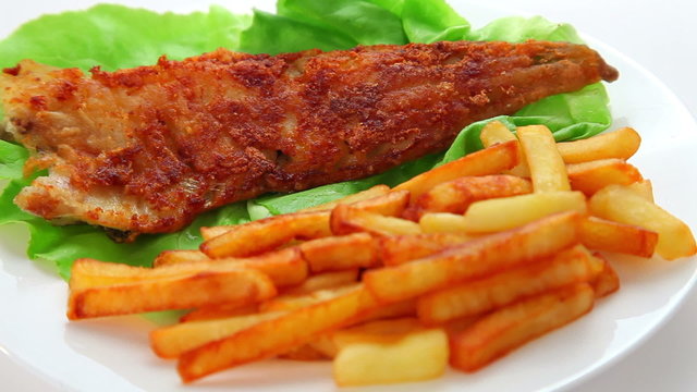 Fried Fish dish - fish fillet on green salad with chips