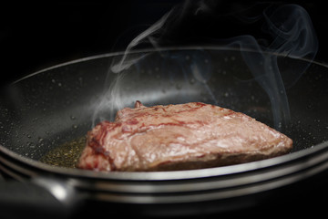 steaming steak in a pan