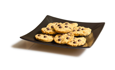 Chocolate chip cookies on a black plate isolated on white backgr