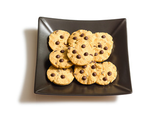Chocolate chip cookies on a black plate isolated on white backgr