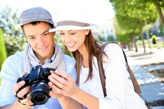Cheerful couple with photo camera in touristic area