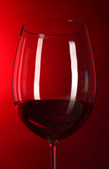 Glass of wine on bright red background