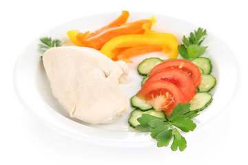 Boiled chicken breast on plate with vegetables close up