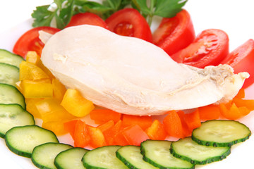 Boiled chicken breast on plate with vegetables close up