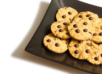 Chocolate chip cookies on a black plate isolated on white backgr