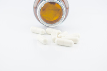 White capsule and brown bottle background
