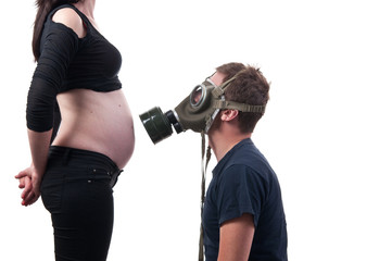 Future dad stay with gas mask in front of his wife's belly, smok © axentevlad