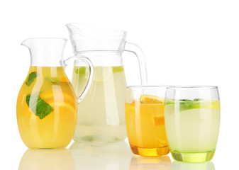 Orange and lemon lemonade in pitchers and glasses isolated