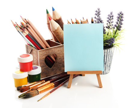 Pencils in wooden crate, paints, brushes and easel, isolated