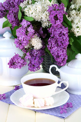 Composition with beautiful lilac flowers, tea service