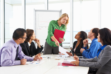 Businesswoman Conducting Meeting In Boardroom