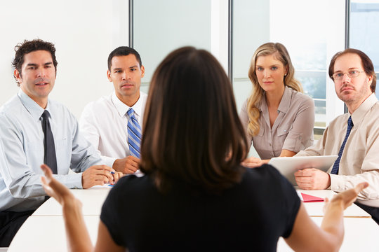 View From Behind As CEO Addresses Meeting In Boardroom