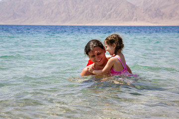 Fototapeta na wymiar Father and baby daughter playing in the water.