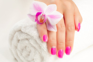Obraz na płótnie Canvas beautiful manicure with pink orchid and towel