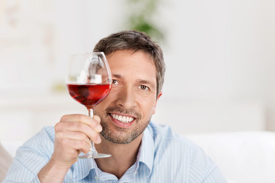 lächelnder mann mit einem glas rotwein