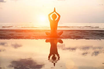  Yoga woman sitting in lotus pose on the beach during sunset © De Visu