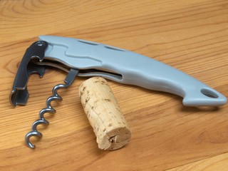 Corkscrewer with the cork on the wooden table