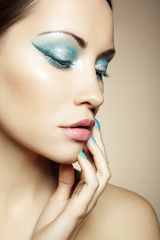 Beautiful young woman with bright make-up and manicure