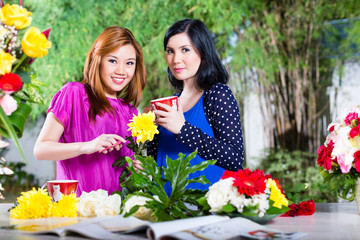 Fototapeta na wymiar Two Asian girlfriends with flowrers