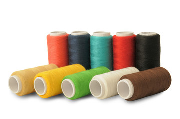 Spools of threads of different colors on white