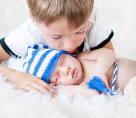 kid boy looking at sleeping newborn baby brother