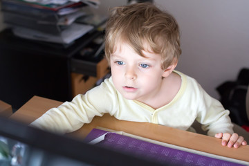 little boy learning on computer  at home