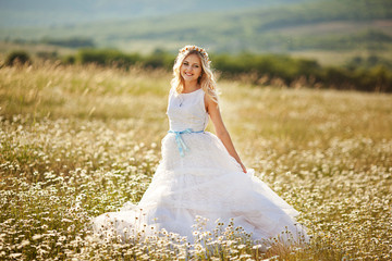Beautiful slim bride in a luxurious wedding dress with flowers