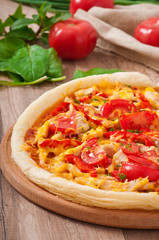 Appetizing pizza with chicken, tomatoes, peppers and cheese