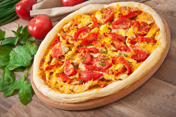 Appetizing pizza with chicken, tomatoes, peppers and cheese