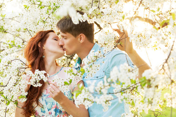 man and woman kissing in flower garden