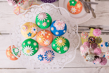Bunte Cupcakes mit Blütendeko von oben