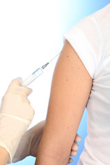 Doctor holding syringe with a vaccine in the patient shoulder,