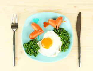 Sausages in form of hearts, scrambled eggs and parsley,