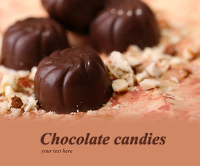 Chocolate candies with nuts, on color background