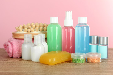 Hotel amenities kit on table on pink background