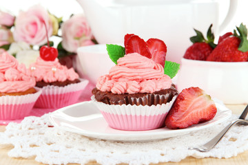 Beautiful strawberry cupcakes on dining table close-up